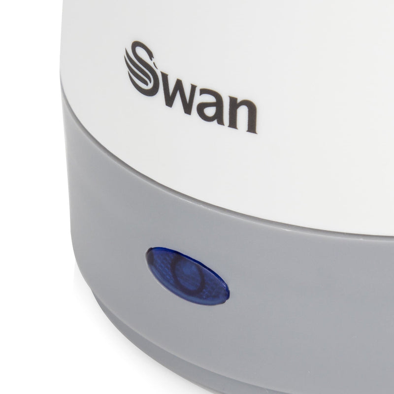 Close-up of the Swan Travel Kettle blue LED light against a white background
