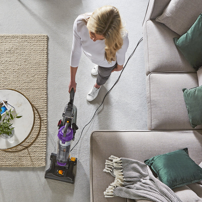 Birdseye photograph of a woman using the Swan Powerspeed Upright Pet Extend Vacuum to clean a cream carpet