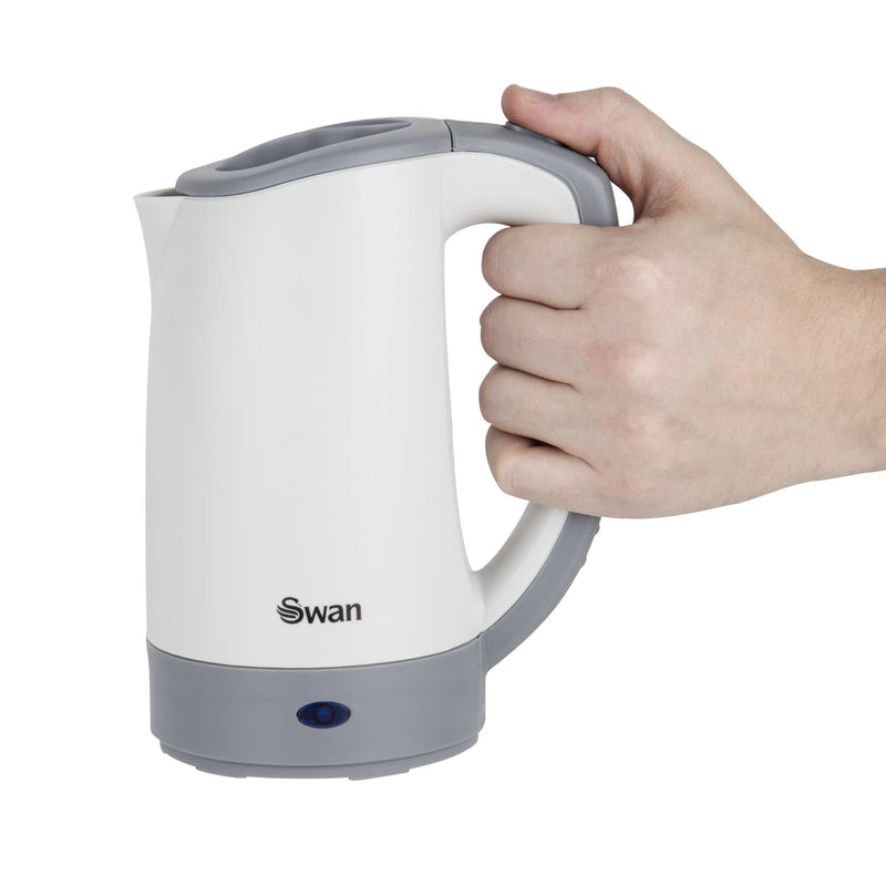 White cutout of male's hand holding the Swan Travel Kettle