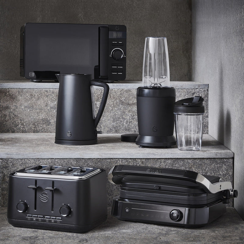 Lifestyle group photograph of the Stealth Microwave, Swan Stealth Kettle, Stealth Personal Blender, Stealth Toaster and Stealth Smart Grill on a marble countertop.